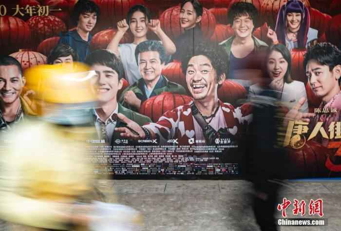 资料图：2020年3月28日，行人经过位于北京市朝阳区望京地区的一家电影院的户外广告。/p中新社记者 侯宇 摄